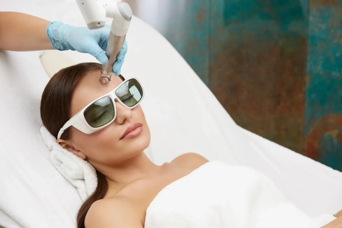 beautician-doing-facial-prosedures-cosmetic-clinic-using-laser-woman-receiving-face-treatment-her-forehead-1200x800.webp